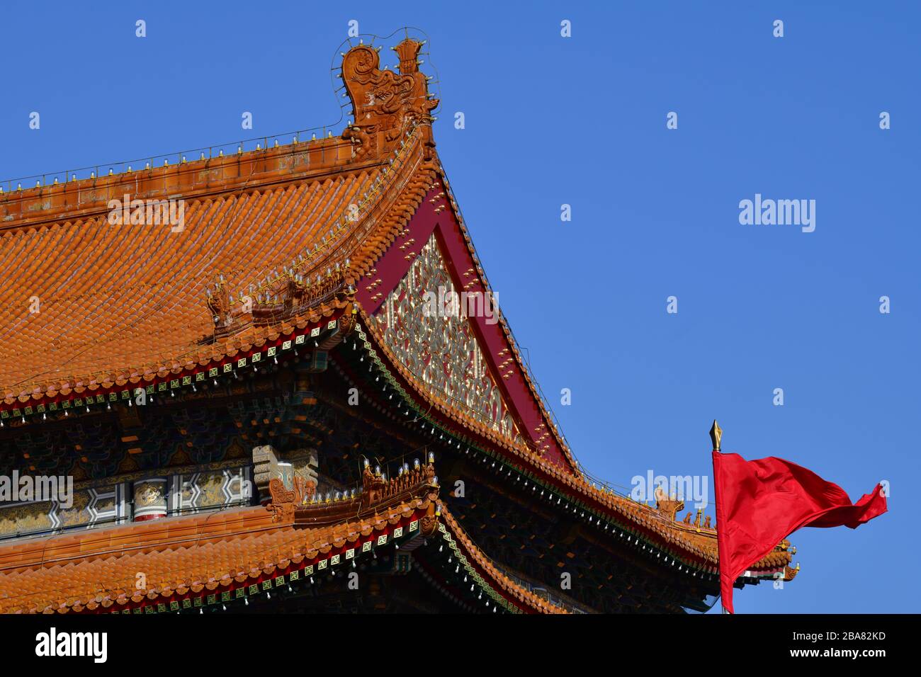Beijing, China - October 2019; Low angle close up view of one of the iconic red roofs of the Forbidden city in Beijing against a blue sky with the typ Stock Photo