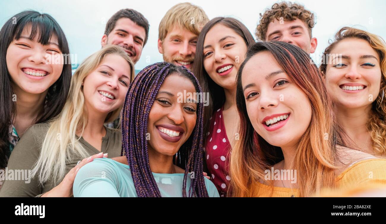 Young friends from diverse cultures and races taking photo making happy faces - Youth, millennial generation and friendship concept with students peop Stock Photo