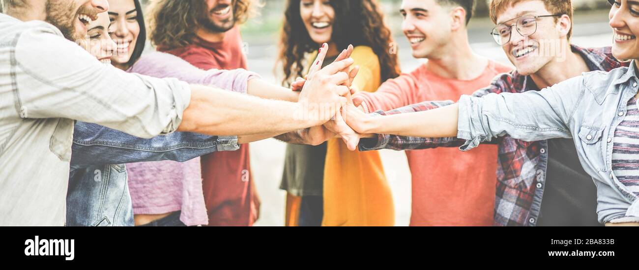 Young happy people stacking hands outdoor - Diverse culture students ...