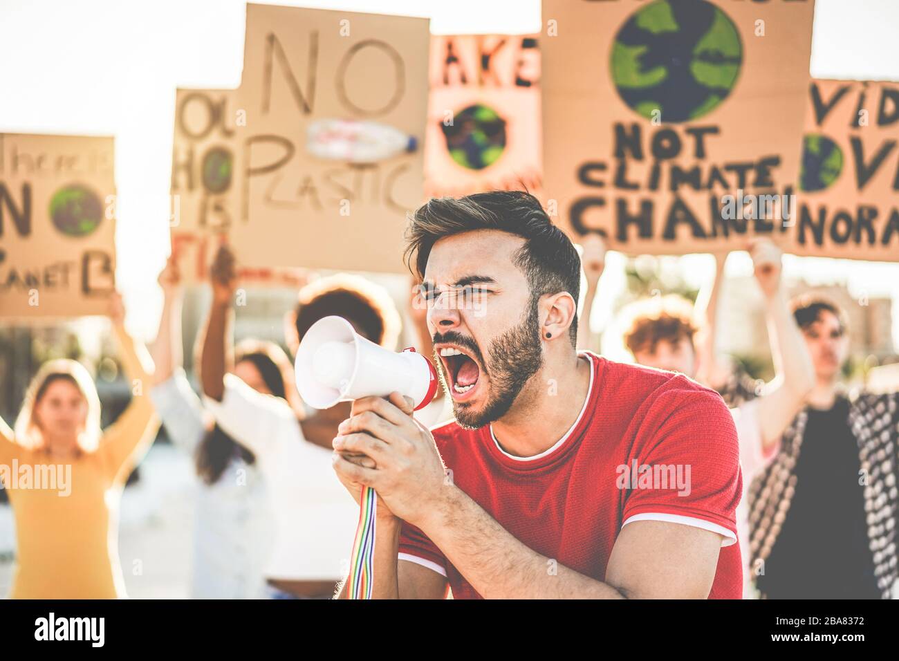 Group of millennials demonstrators on road, young people from different culture and races fight for plastic pollution and climate change - Global warm Stock Photo