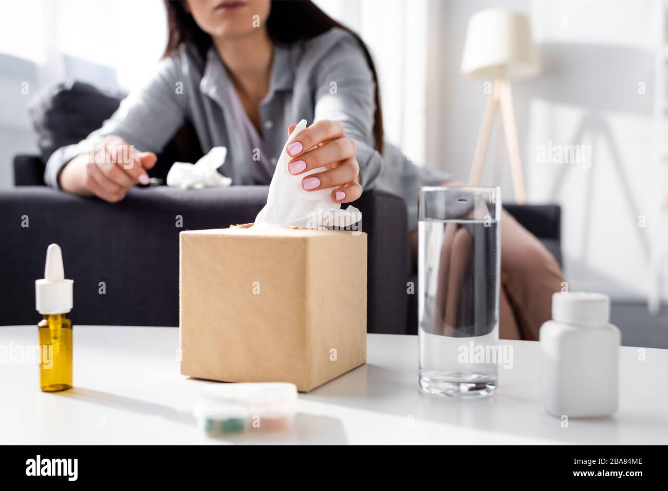cropped view of allergic woman taking tissue near glass of water