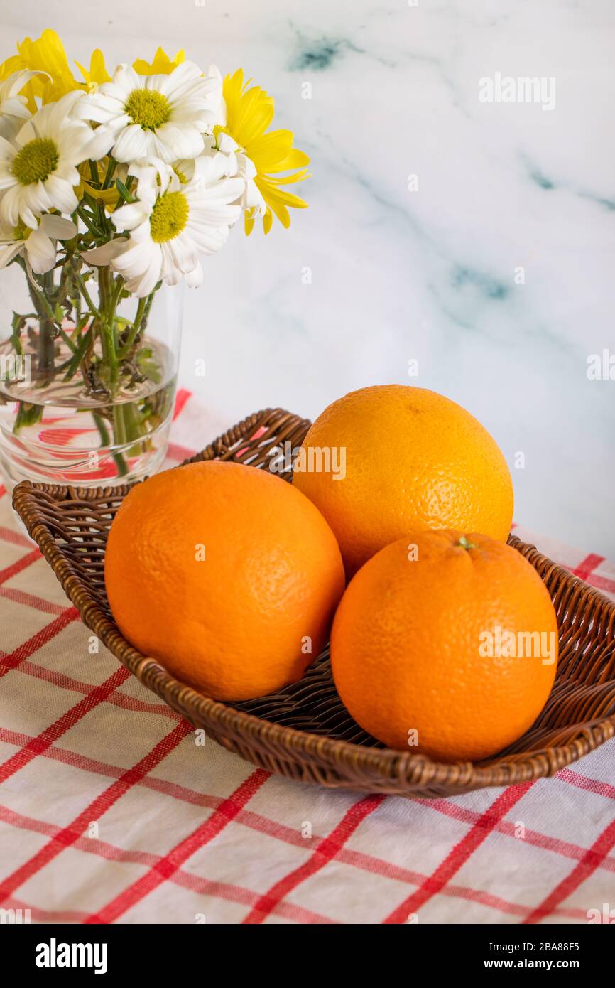 Oranges in a platter on the checked tablecloth Stock Photo