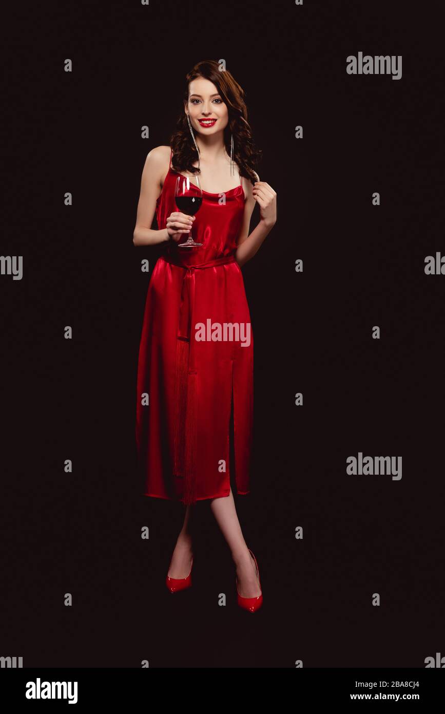 Full length of beautiful woman in dress holding glass of red wine and ...