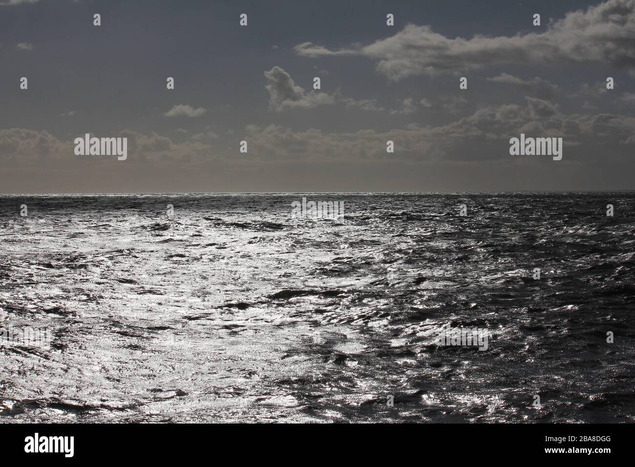 Shimmering silver sea stretching to the horizon Stock Photo