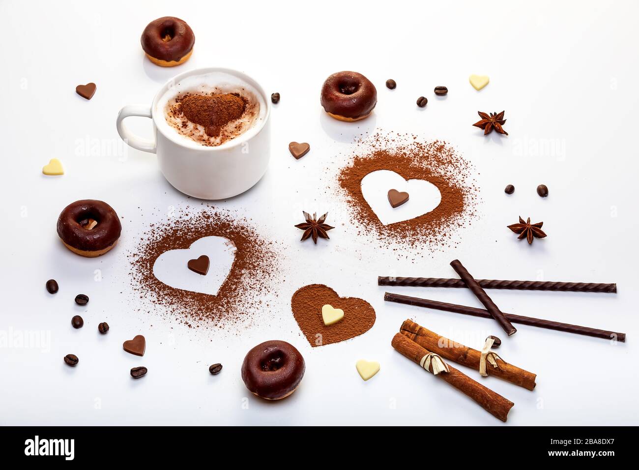 Cocoa powder in the shape of heart, chocolate doughnuts and cup of cappuccino. Valentines day design concept of postcards and banners Stock Photo