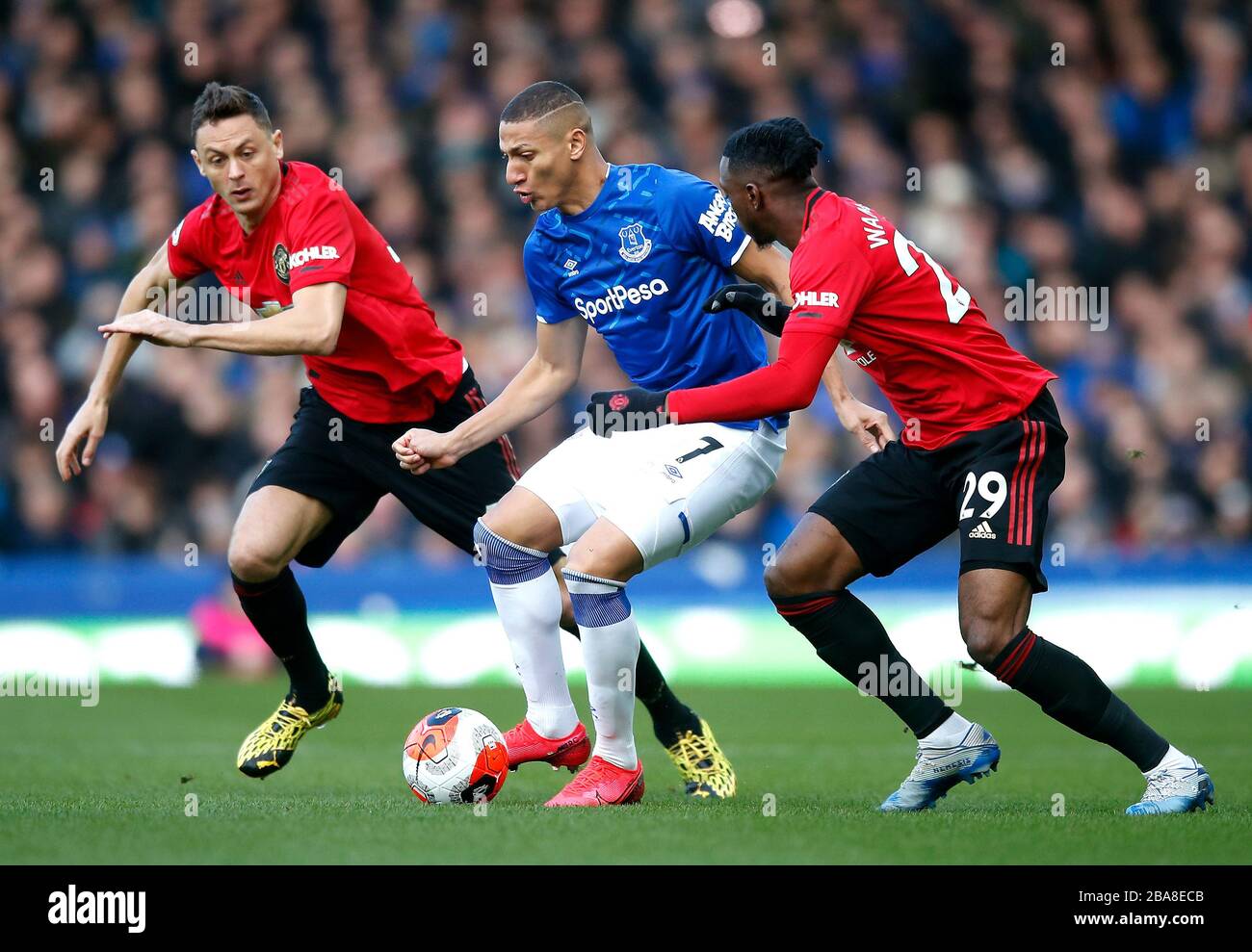 Everton's Richarlison (centre) battles for the ball with Manchester United's Nemanja Matic (left) and Aaron Wan-Bissaka Stock Photo