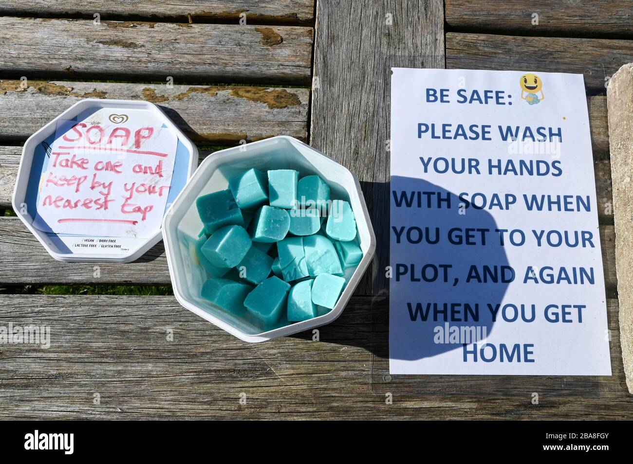 Covid19 hygiene. A container of complimentary soap with instructions to wash hands on an allotment garden during the coronavirus pandemic. Stock Photo