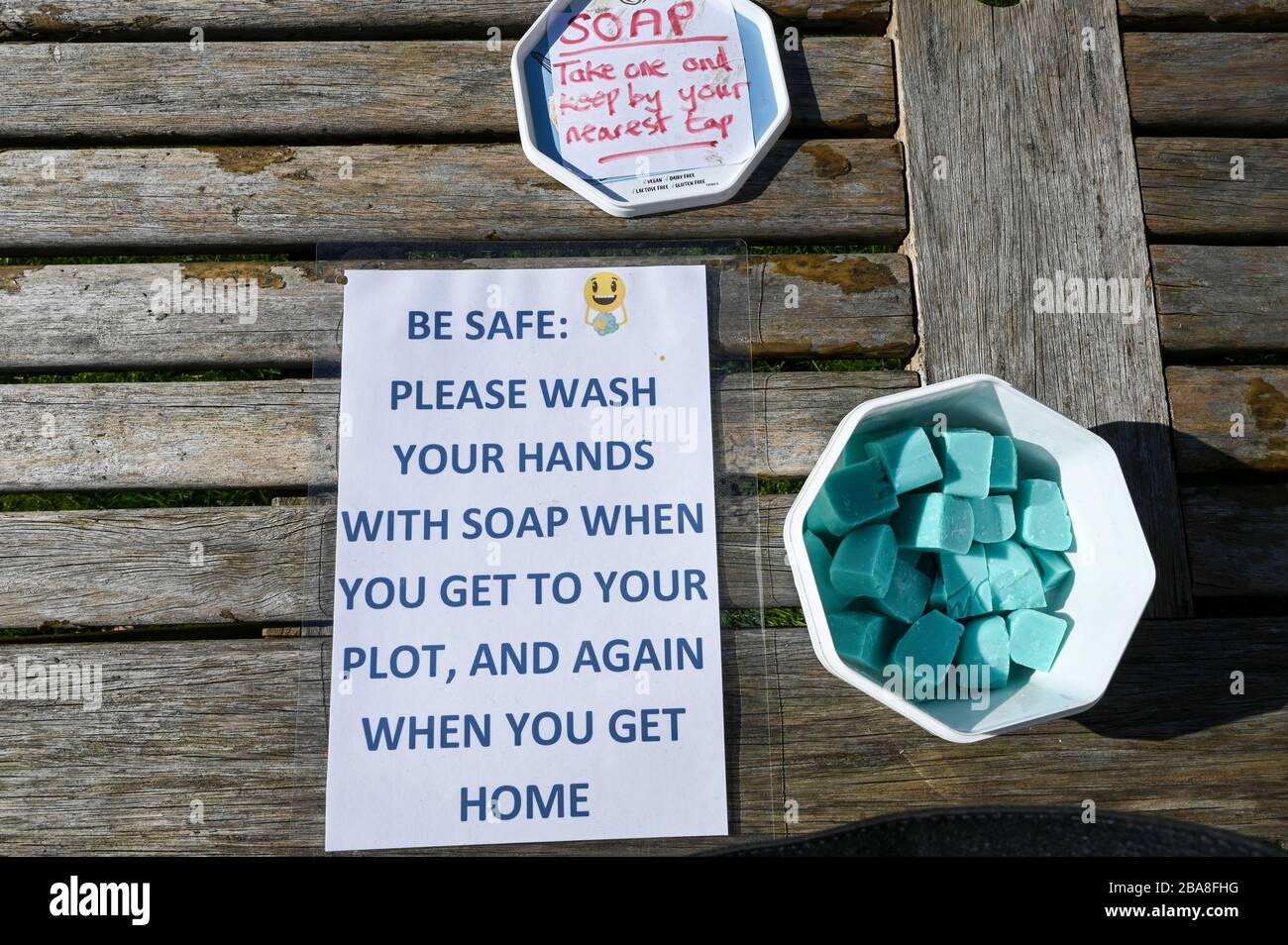 Covid19 hygiene. A container of complimentary soap with instructions to wash hands on an allotment garden during the coronavirus pandemic. Stock Photo