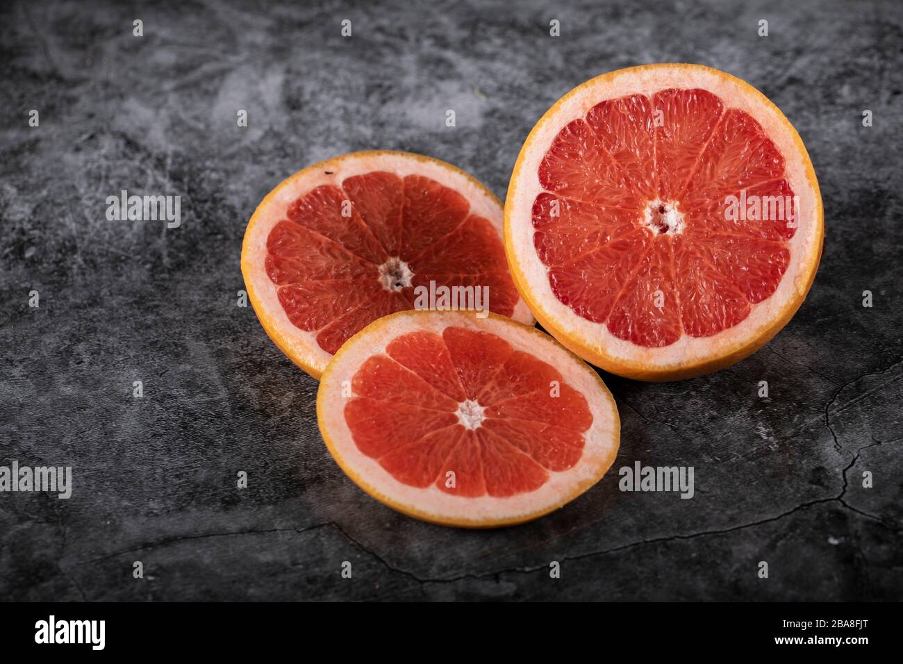 Sliced juicy fresh grapefruit on a marble Stock Photo
