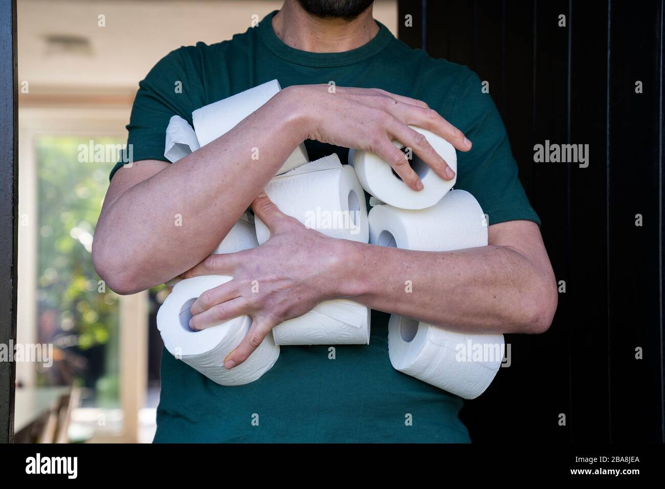 Man hoarding toilet roll during Coronavirus pandemic panic buying. Stock Photo