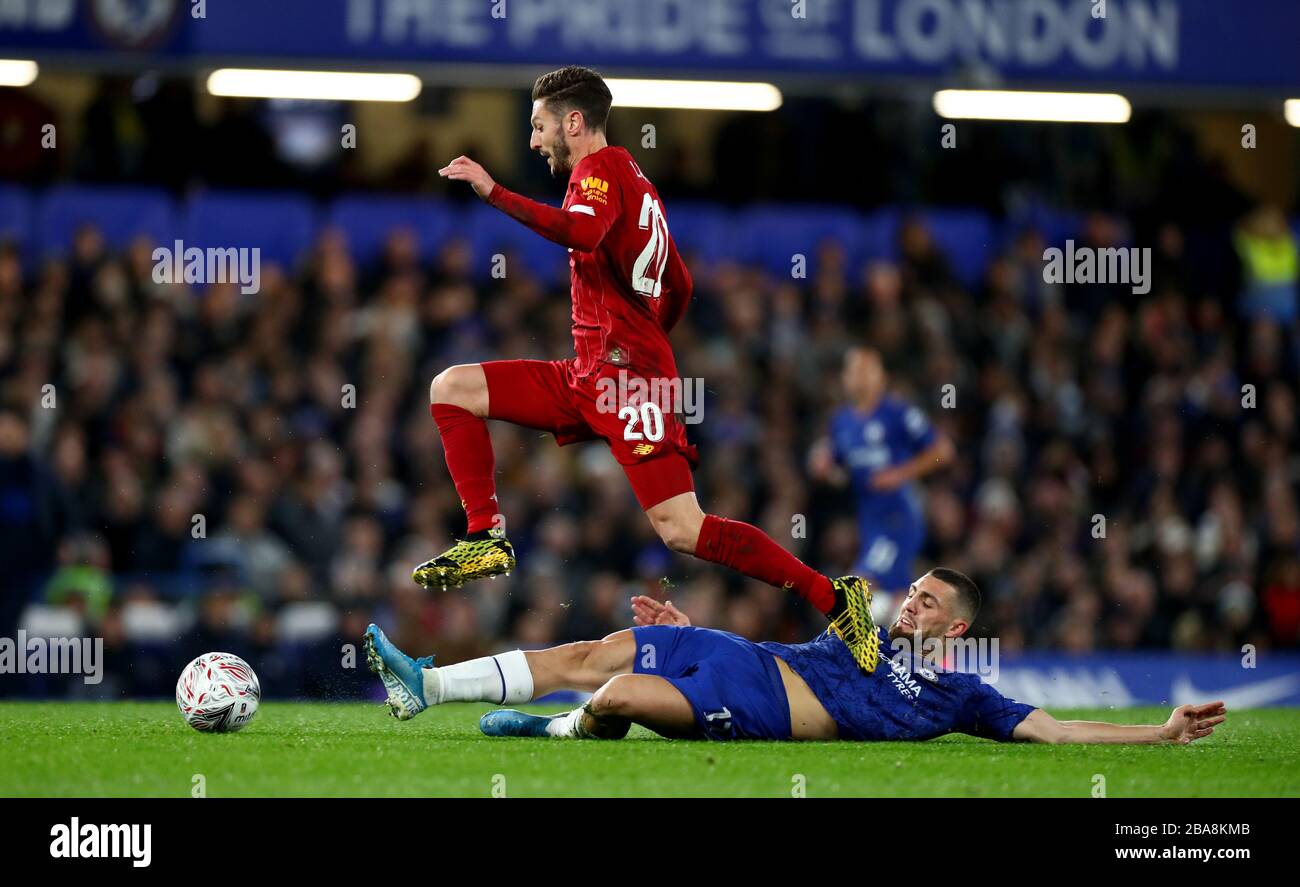 Chelsea's Mateo Kovacic (bottom) attempts a slide tackle on Liverpool's Adam Lallana Stock Photo