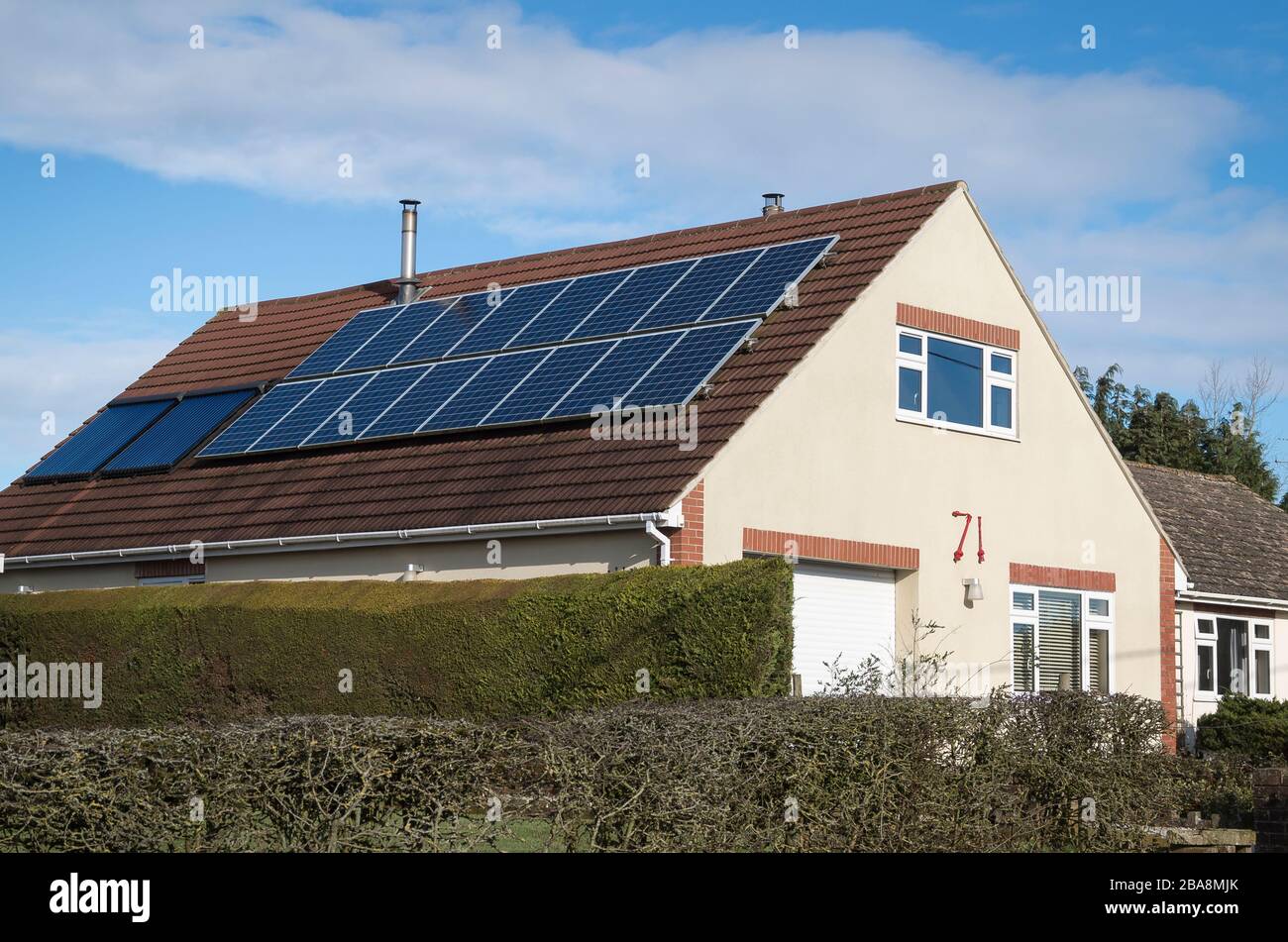 An array of solar heating panels on the south-facing roof of a chalet bungalow in Bromham Wiltshire England UK Stock Photo