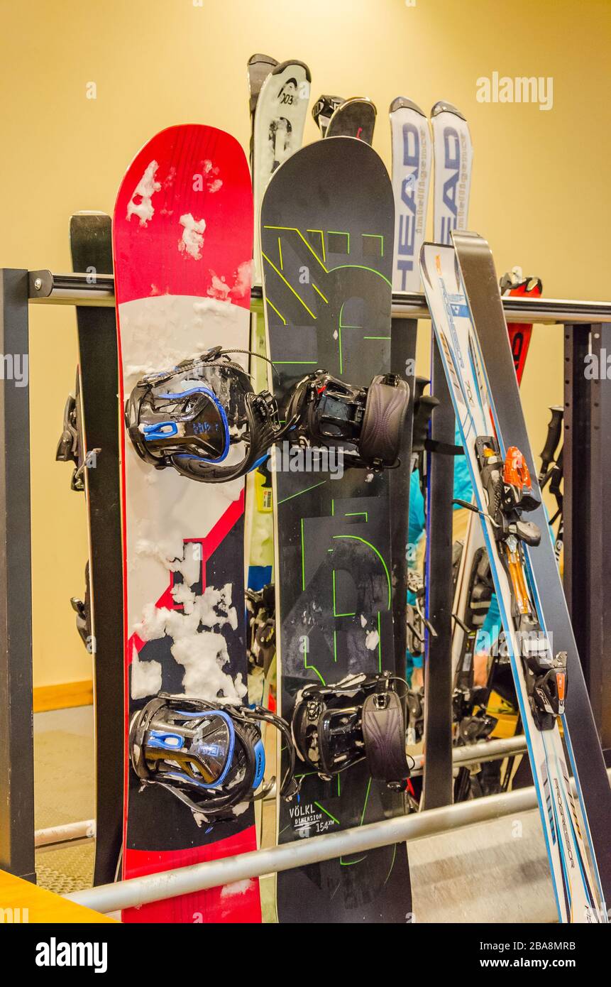 St. Petersburg, Russia - 01.01.2019: snowboards and skis at desk of a ski resort in winter. Vertical photo. Stock Photo