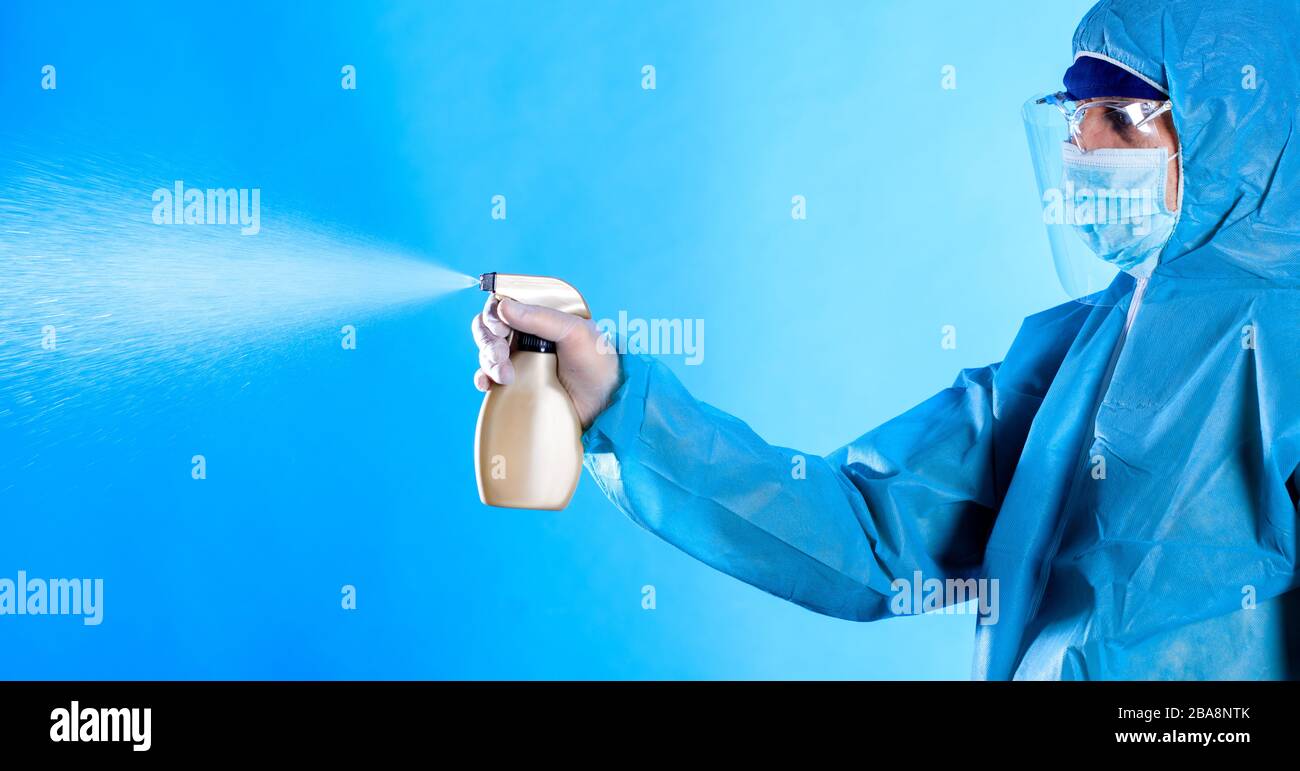 man in a blue full protected suit with disinfectant , coronavirus pandemic Cleaning and