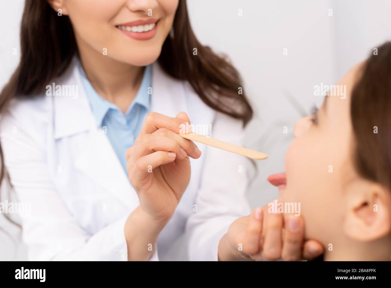 Doctor examining girl tongue depressor hires stock photography and