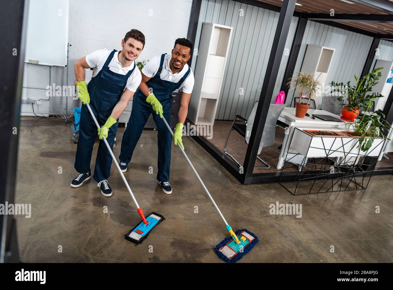 Two smiling multicultural cleaners hi-res stock photography and images ...