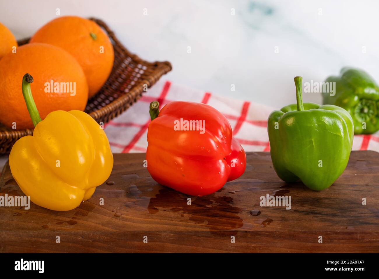 Tricolor bell peppers on a cutting board Stock Photo - Alamy