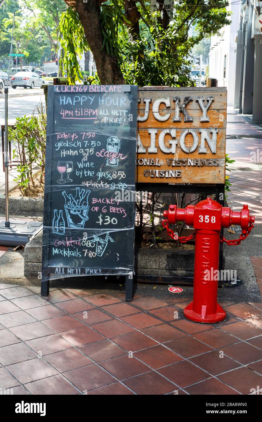 Happy hour price list on a chalk board outside a bar in Singapore Stock