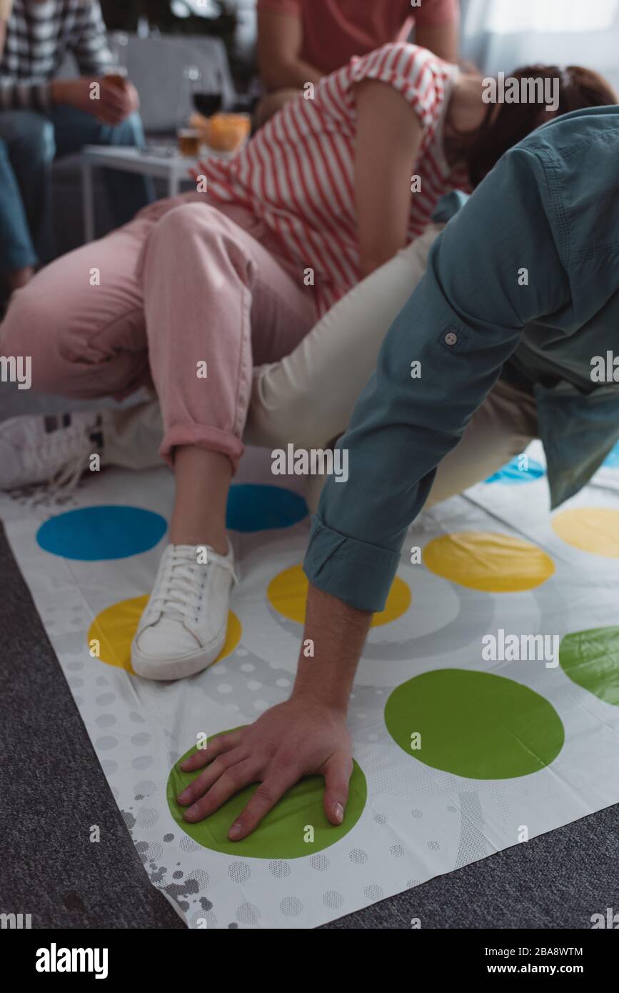 KYIV, UKRAINE - JANUARY 27, 2020: cropped view of friends playing twister game at home Stock Photo