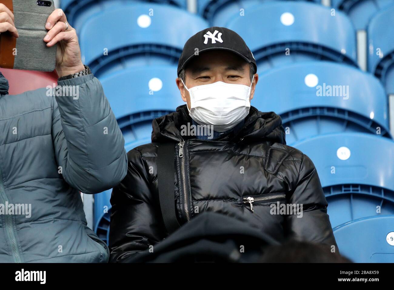 A Burnley fan wears a face mask for protection against the ongoing Coronavirus outbreak Stock Photo