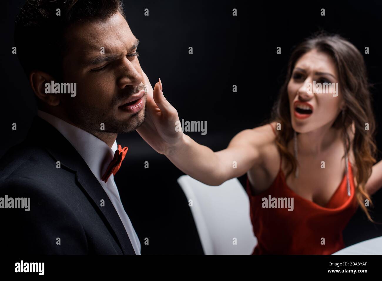Selective focus of screaming woman slapping elegant boyfriend at table ...
