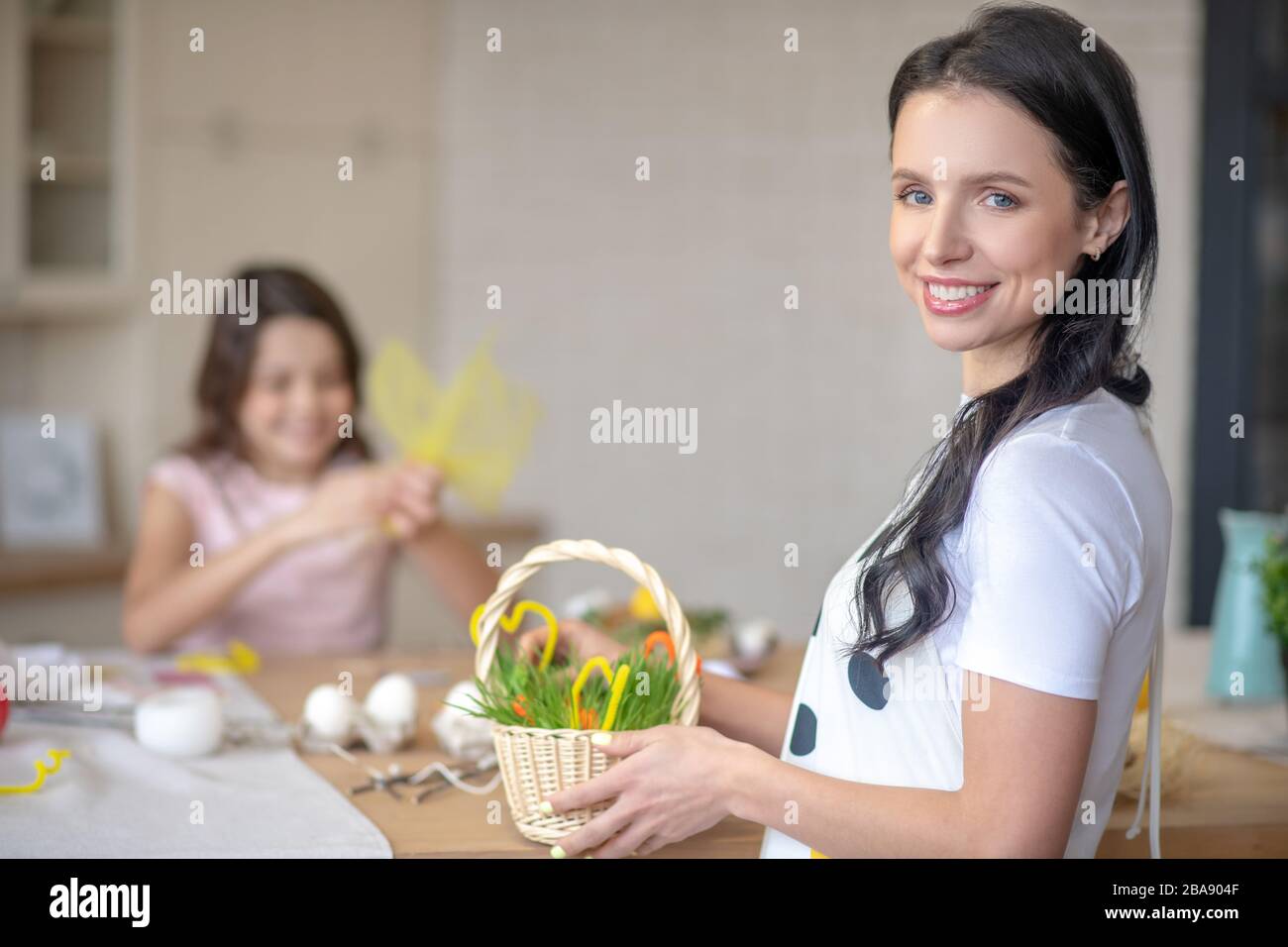 Pretty brunette woman holding easter basket in her hands Stock Photo