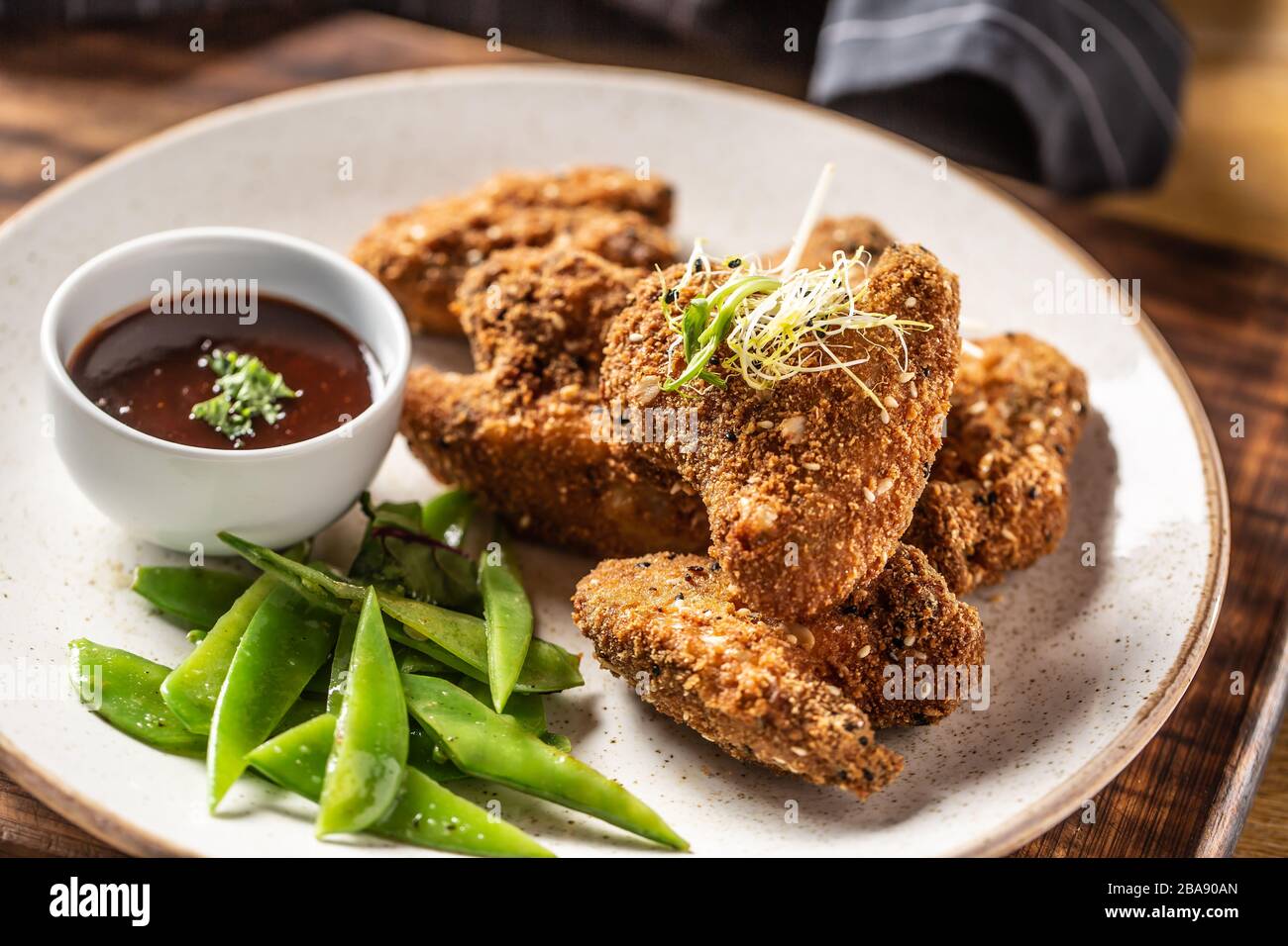 Fried chicken wings with sugar peas and herbs Stock Photo Alamy