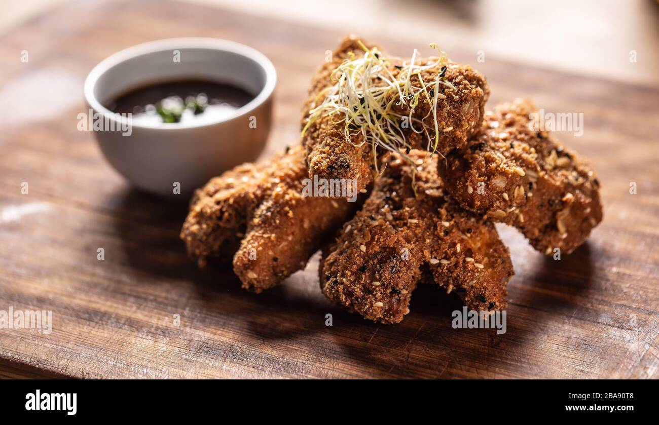 Fried chicken wings on wooden butcher board Stock Photo