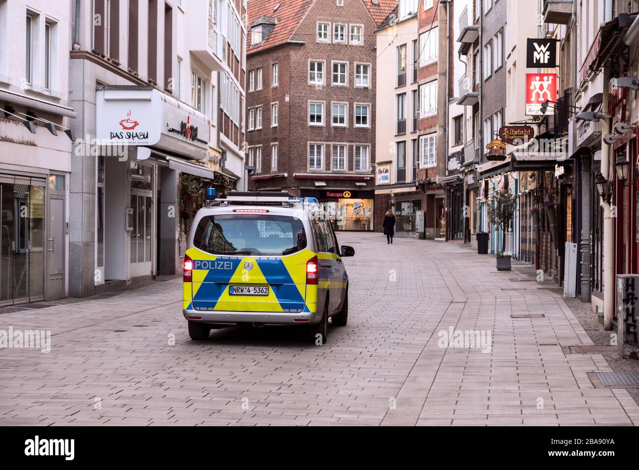 Police drive patrol to control the ban on contact with the coronavirus pandemic in the Alstadt pub and shopping district of Dusseldorf. Stock Photo