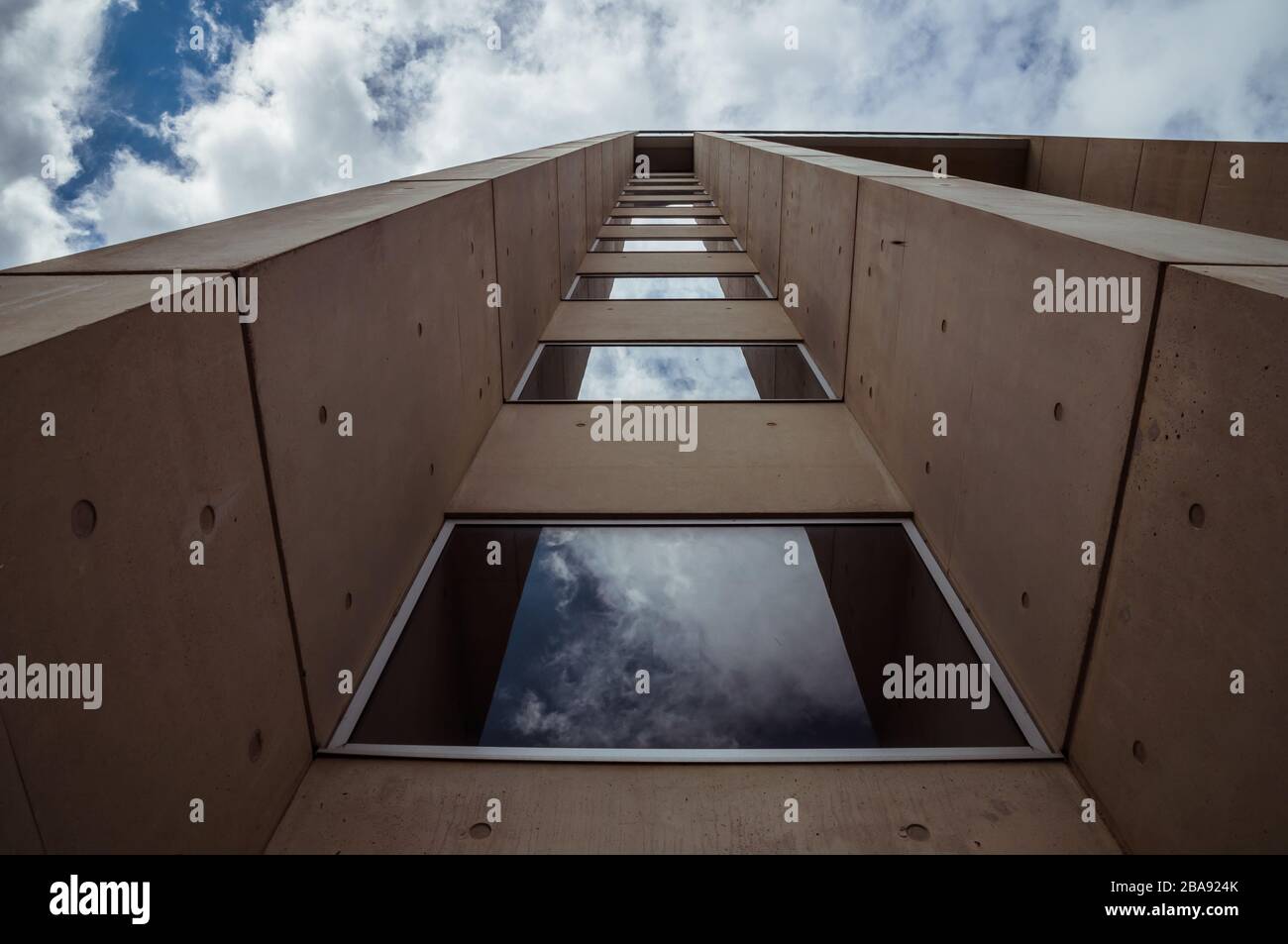Beautiful architecture details of a modern building of concret an fiberglass, with a view on a blue cloudy sky Stock Photo