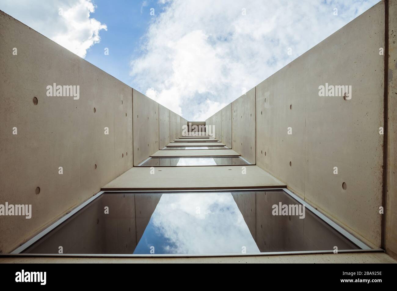 Beautiful architecture details of a modern building of concret an fiberglass, with a view on a blue cloudy sky Stock Photo