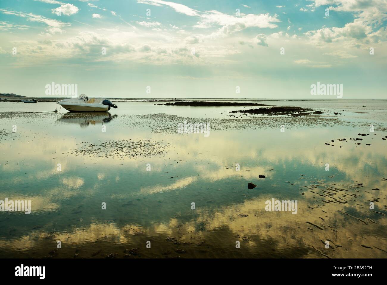 Motor boat beached by low tide at French Atlantic coast. Picturesque landscape in Vendee department, close to La Tranche sur Mer. Beautiful reflection Stock Photo