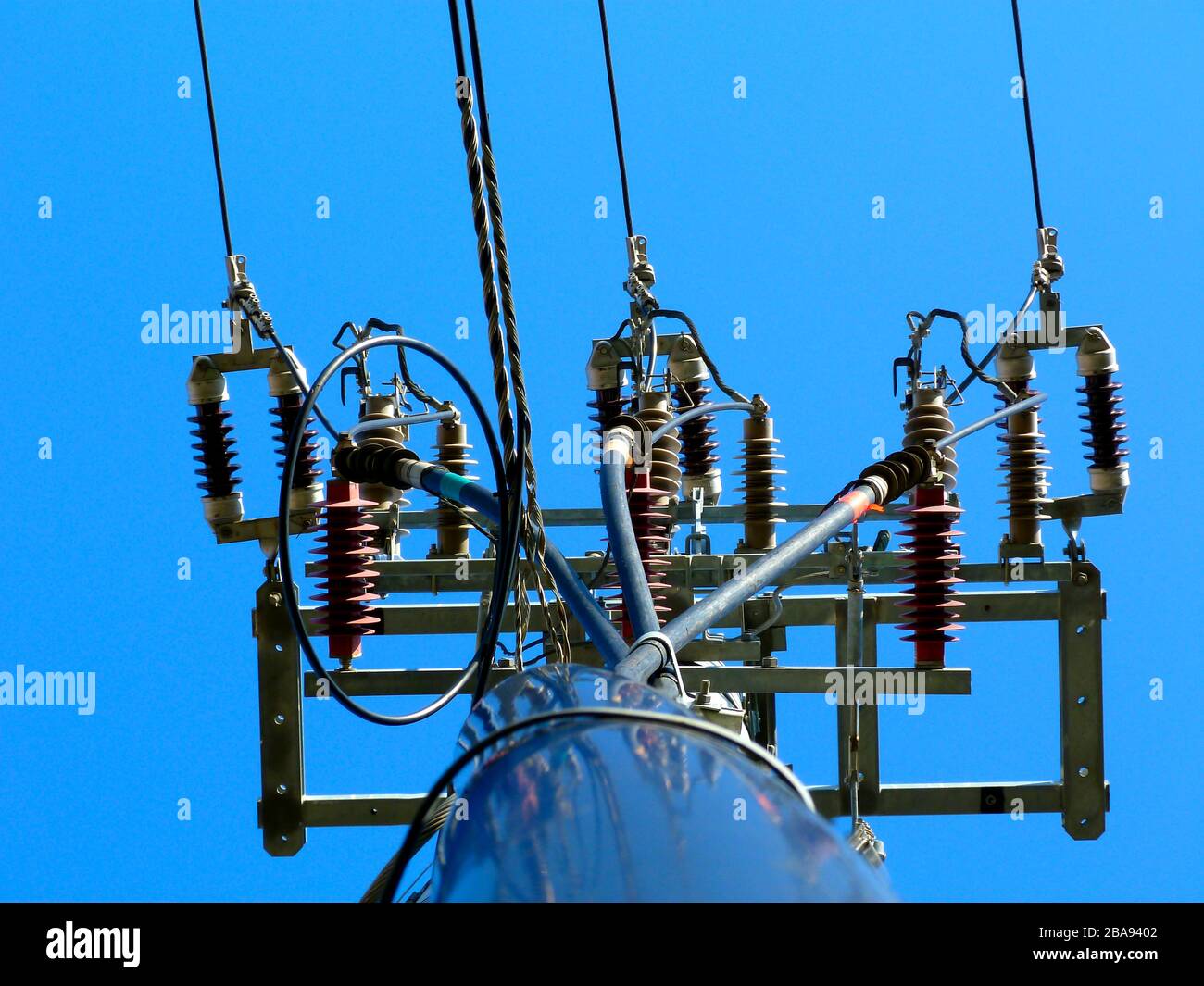 electrical wires on concrete pole. cables vertically dropping. blue sky