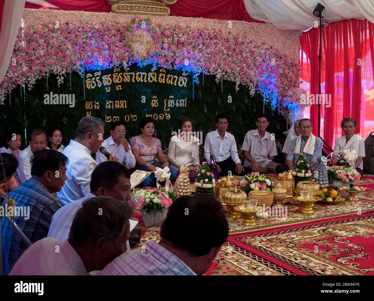 Kampot, Cambodia, Asia: a group of friends and relatives participate seated in the celebration of a wedding Stock Photo