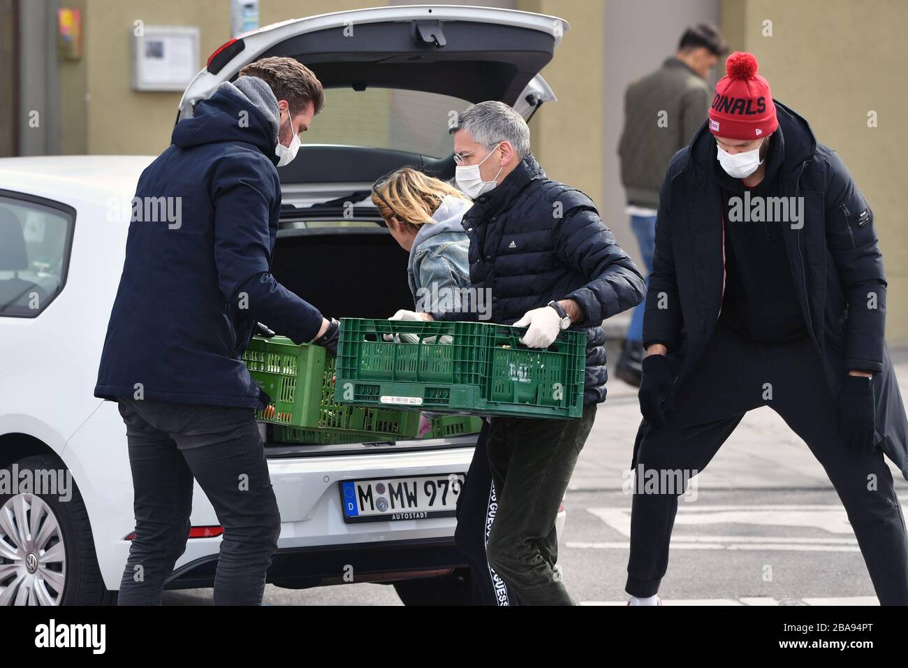 Herbert HAINER (President FC Bayern Munich, withte), DANILO BARTHEL (FCB, right) and Marko PESIC (left) are lifting boxes with knickers from a car - they wear face masks and protective masks. FC Bayern Munich Basketball is helping the Muenchener Tafel on 26.03.2020 in the wholesale market in Muenchen. @Sven Simon Photo Agency. GmbH & Co. Press Photo KG # Prinzess-Luise-Str. 41 # 45479 M uelheim / R uhr # Tel. 0208/9413250 # Fax. 0208/9413260 # GLS Bank # BLZ 430 609 67 # Kto. 4030 025 100 # IBAN DE75 4306 0967 4030 0251 00 # BIC GENODEM1GLS # www.svensimon.net. | usage worldwide Stock Photo