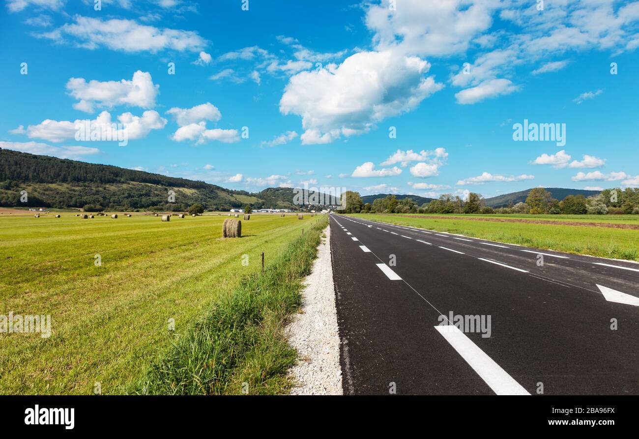 asphalt road through the green field and clouds on blue sky Stock Photo ...
