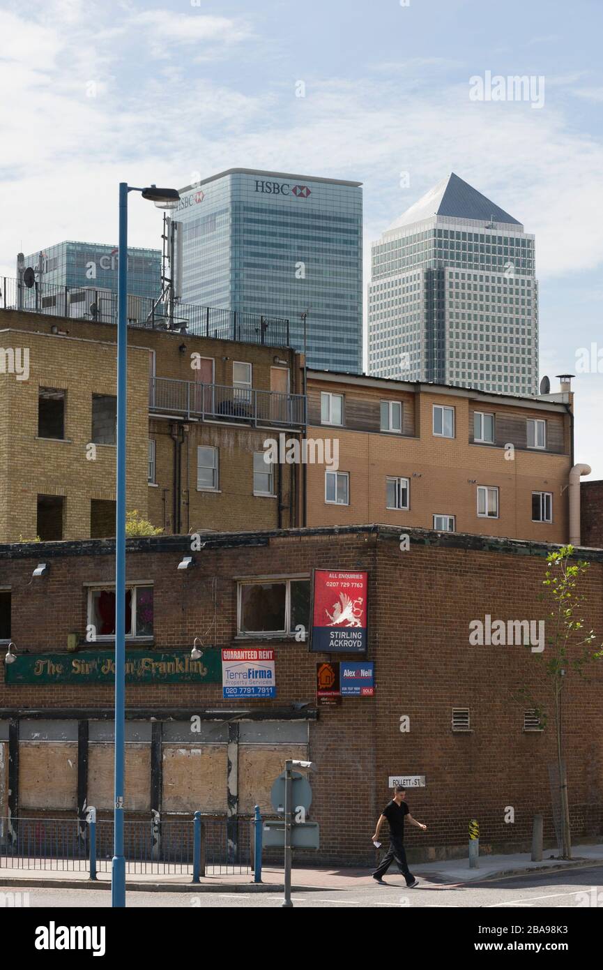 Derlict pub, East India Dock Road, Poplar Tower Hamlets, London with Tower blocks of Canary Wharf, financial district, behind. The London Borough of T Stock Photo