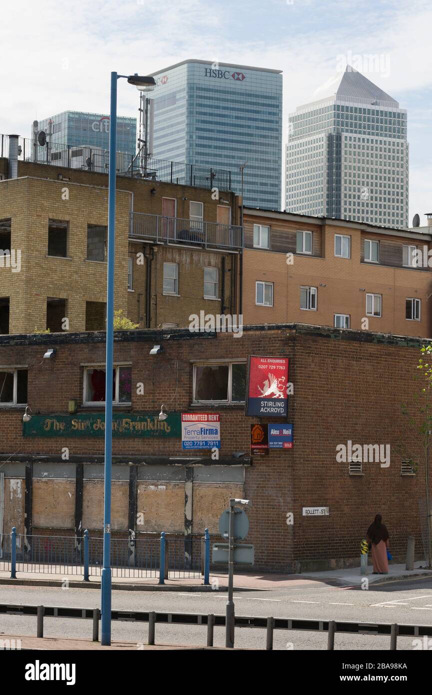 Derlict pub, East India Dock Road, Poplar Tower Hamlets, London with Tower blocks of Canary Wharf, financial district, behind. The London Borough of T Stock Photo