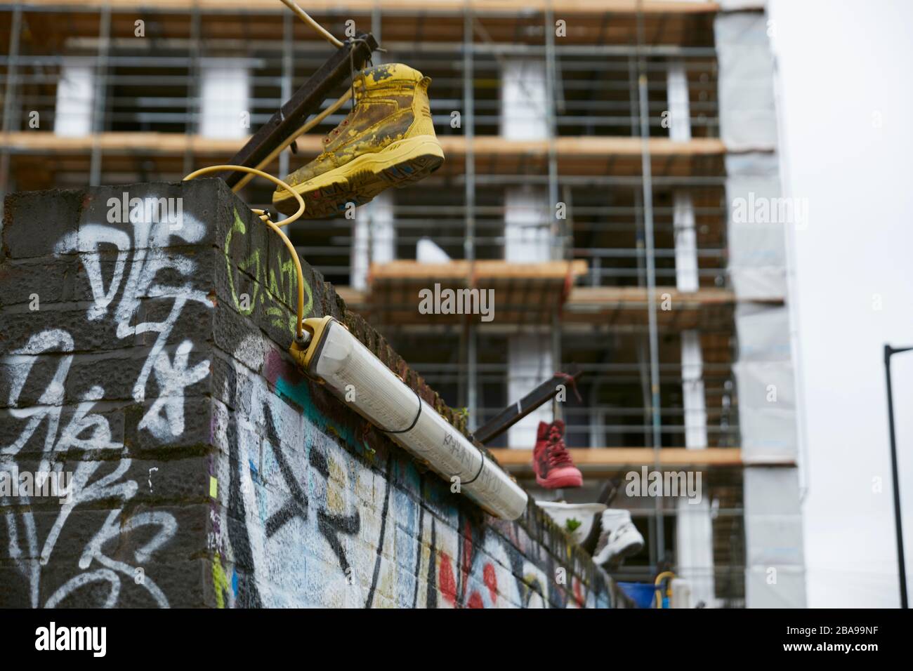 Zapatillas en una obra en el barrio de Hackneywick en Londres Stock Photo
