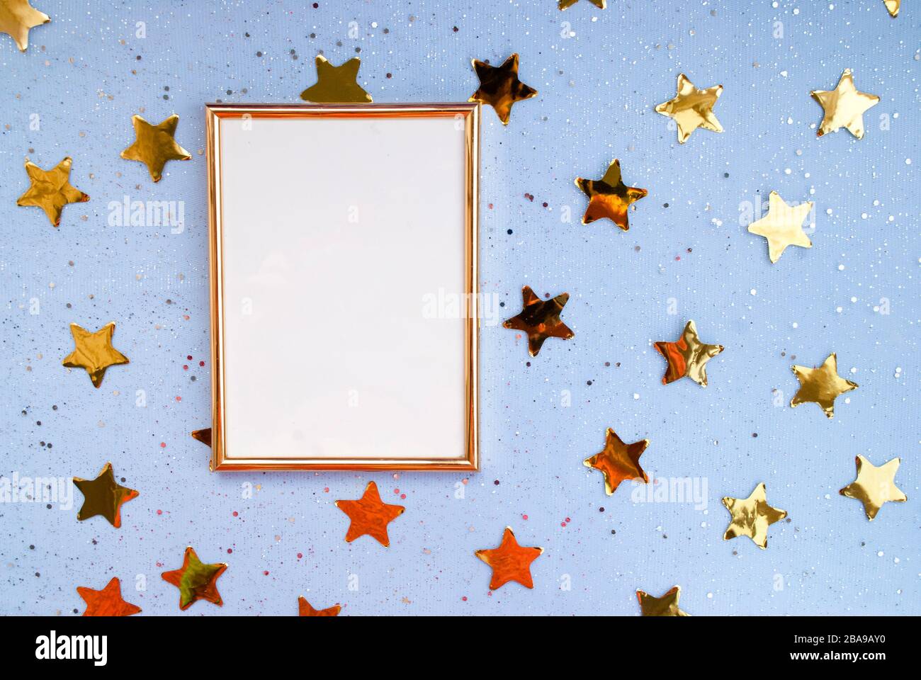 Festive background. Gold photo frame, small shiny confetti, place for text,  gold stars, blue background Stock Photo - Alamy
