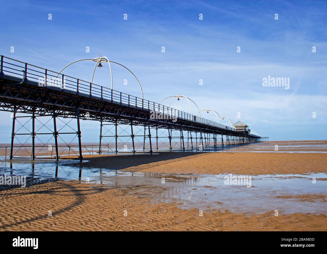 Southport Pier viewed from the beach with patterns of residual water in the foreground Stock Photo