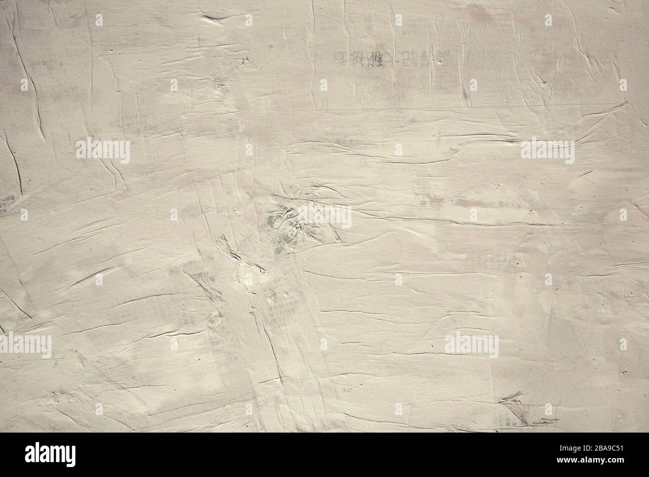 Background wall of Asian newspaper painted over in warm white paint Stock Photo