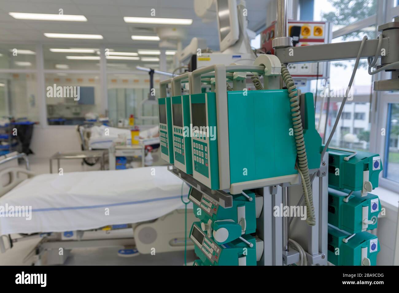Beam with infusion pumps and syringe pumps, on background beds in ICU