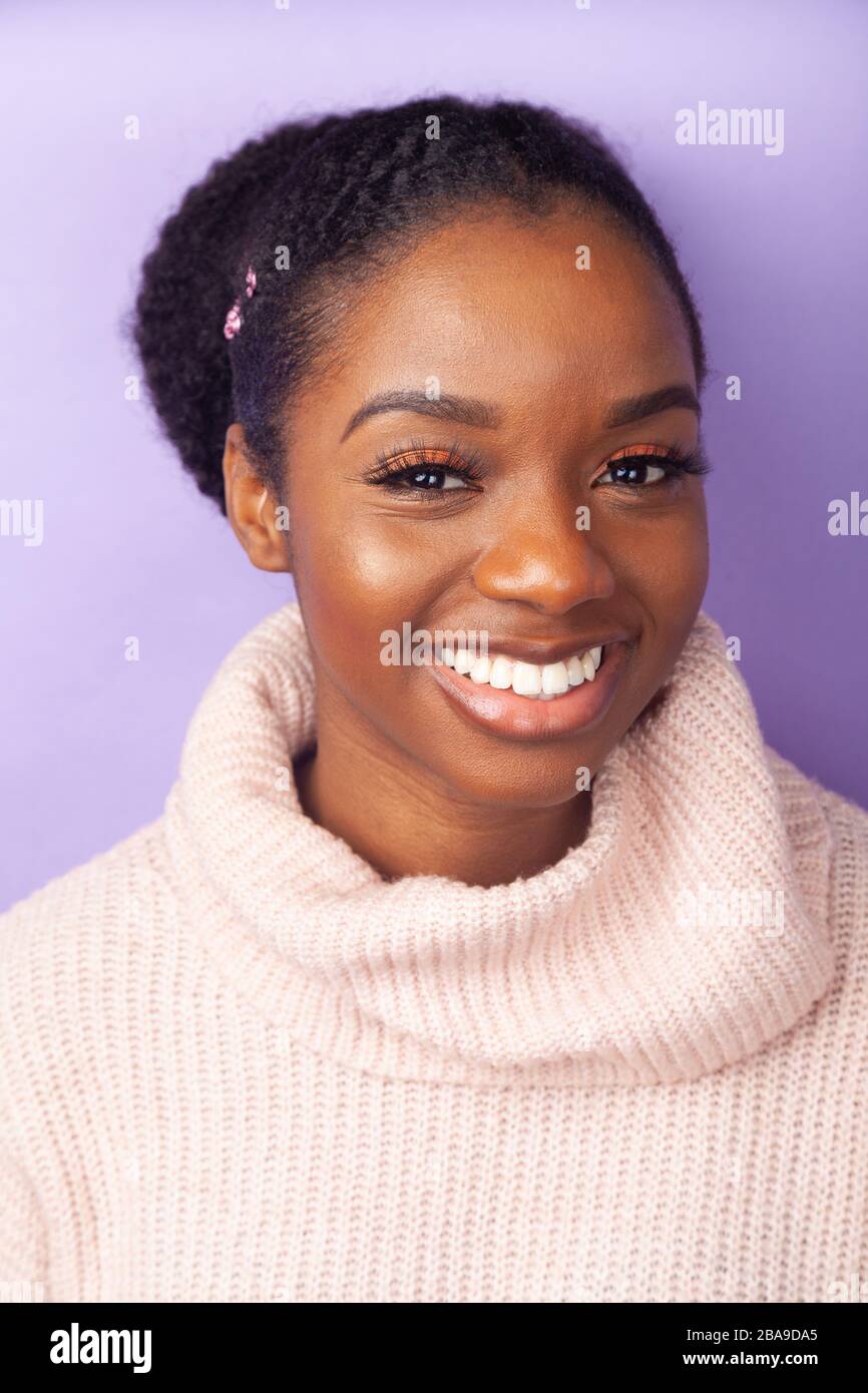 Portrait of a beautiful young woman smiling and  wearing a woollen jumper Stock Photo
