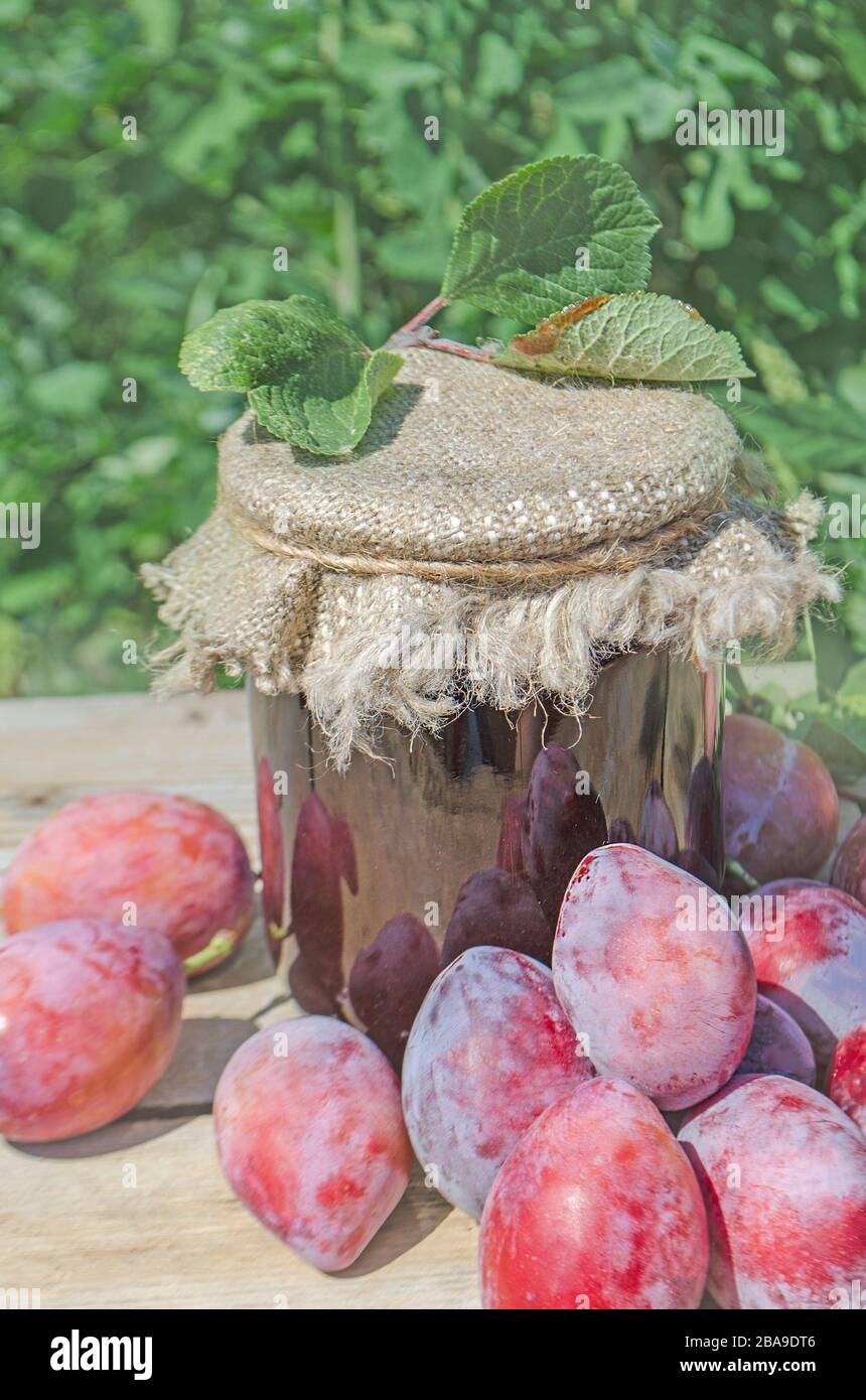 Glass with plum jam on an old wooden table Stock Photo