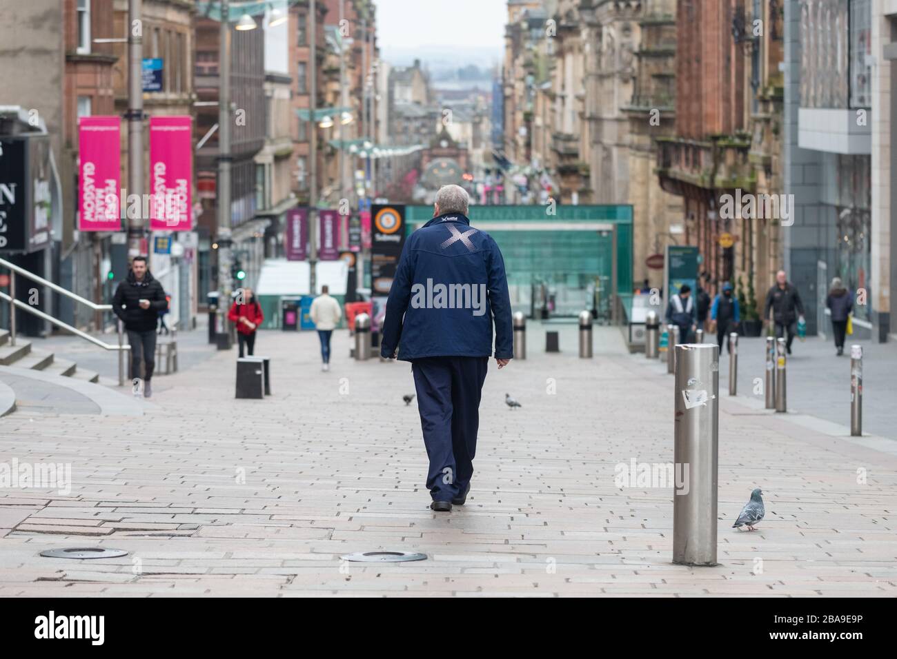 Glasgow, Scotland, UK. 26th Mar, 2020. Coronavirus lockdown Glasgow, Scotland: A Scotrail keyworker one of only a few people on the streets of Glasgow city centre at lunchtime during the coronavirus lockdown . Credit: Kay Roxby/Alamy Live News Stock Photo