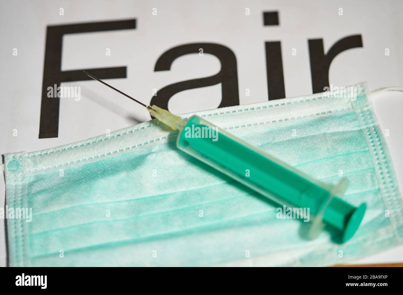 Covid-19 symbol in  Marktoberdorf, Germany, March 26, 2020. Injection needle for vaccination and a mouth protection. Due to the Corona virus disease (COVID-19) a Fairness, collegiality, hug, congratulations, fair, payment for workers in the health system in necessary. on March 26, 2020 in Marktoberdorf, Germany  © Peter Schatz / Alamy Live News Stock Photo