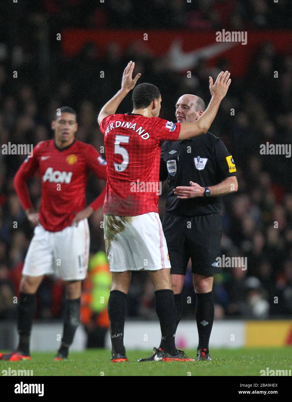 Manchester United's Rio Ferdinand (left) complains to referee Mike Dean (right) Stock Photo