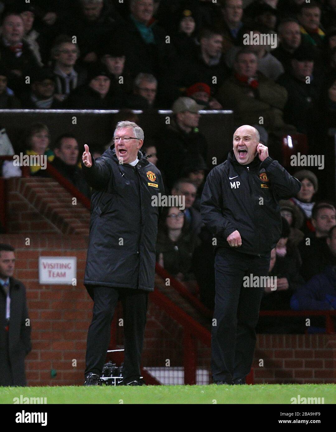 Manchester United manager Sir Alex Ferguson (left) and his assistant Mike Phelan (right) gesture on the touchline Stock Photo