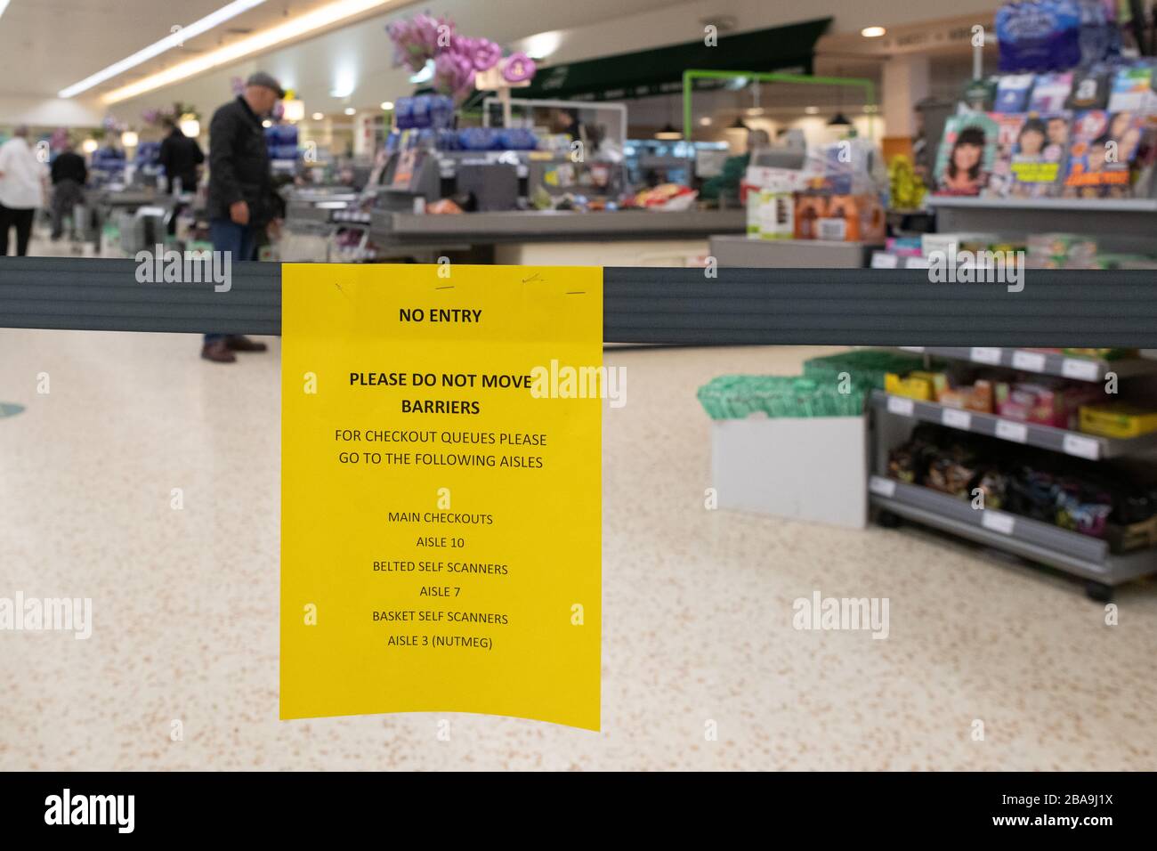 Glasgow, Scotland, UK. 26th Mar, 2020. Coronavirus lockdown Glasgow Scotland: a customer pays for his shopping inside a Morrisons supermarket in Glasgow. A new single queuing system is in place and restricted numbers are allowed in the store to enable customers to keep a trolley's length distance from others at all times Credit: Kay Roxby/Alamy Live News Stock Photo